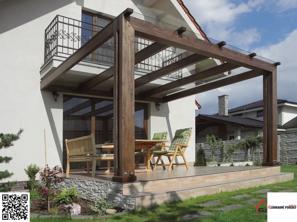 Drevená pergola s tmavou konštrukciou a sklenenou strechou nad terasou rodinného domu